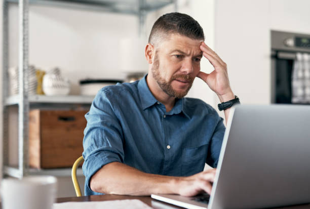 istock Shot of a businessman experiencing a headache while working from home 1352038153