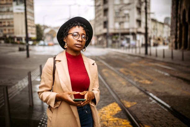 Young woman on the road tries to stop taxi car. Young, cute, black student woman in rush trying to stop a taxi on rainy cold autumn day black taxi stock pictures, royalty-free photos & images