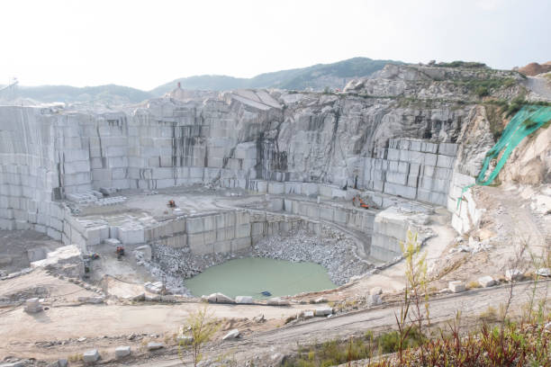 istock Quarry excavator hydraulic hammer crushes large stones in a limestone quarry. 1352040628