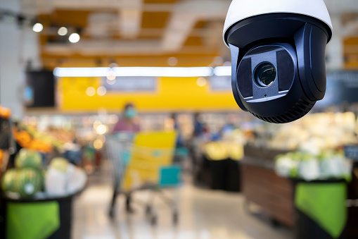 CCTV and blurred supermarket store blur background. Business protection.