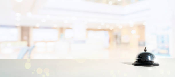 istock Bell service with bokeh. Hotel service bell on a table white glass and simulation hotel background. 1352040672