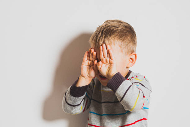 istock Portrait Of Boy Standing Against Wall 1352040746