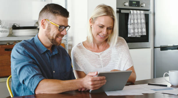 istock Shot of a couple using their digital tablet and going through bills together 1352041478