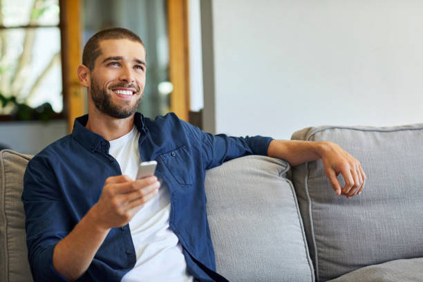 istock Happy man watching TV at home in quarantine 1352042527