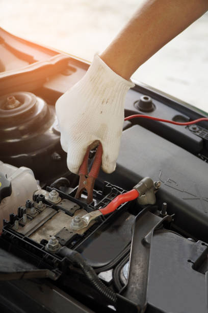 istock Mechanic is using electric car battery charger through jumper wires. 1352044262