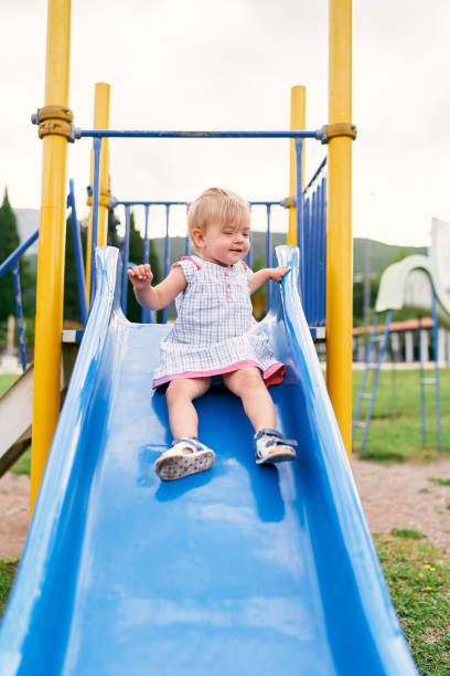 istock Boy Playing On Slide At Playground 1352046814