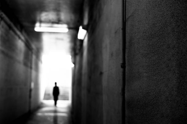 istock Image of a man walking in a tunnel, Monochrome 1352048159
