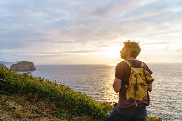 istock Panoramic view of unrecognizable man at sunset in a cliff. 1352049233