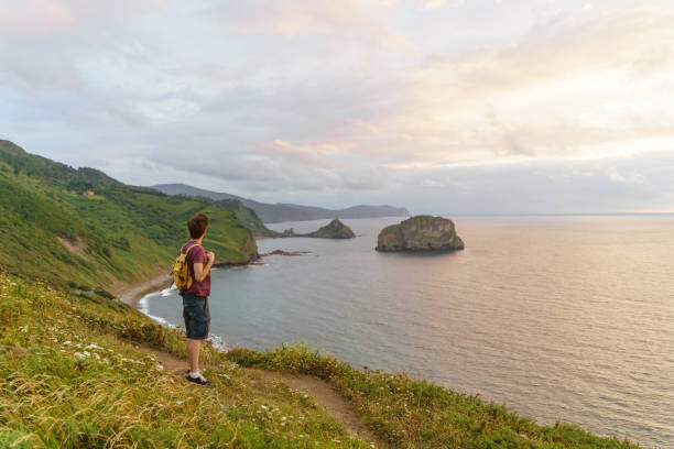 istock Panoramic view of unrecognizable man at sunset in a cliff. 1352049276