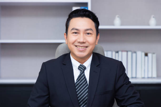 istock Handsome cheerful Asian man executive business man at the workspace office manager. 1352050281