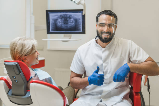 istock Successful confident Middle-Eastern male dentist orthodontist stomatologist looking at camera showing thumb up while patient client waiting for tooth teeth filling cleaning 1352050517