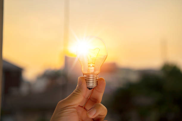 istock Hand holding light bulb against nature on green leaf with energy sources for renewable 1352050855