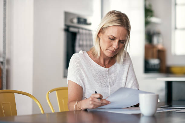 istock Shot of a woman reading through contracts before signing them 1352052957