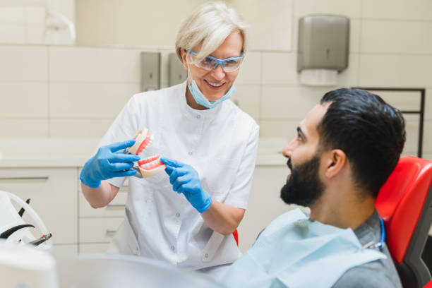 istock Caucasian stomatologist female dentist orthodontist showing explaining teeth tooth problems diagnosis on dental jaws miniature 1352053104