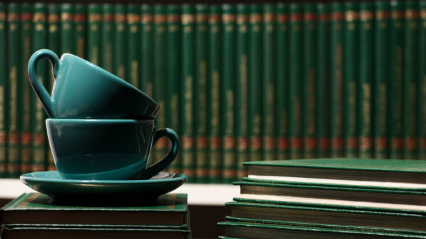 istock two green cups with hot tea, books, black background space for texts, 1352053259