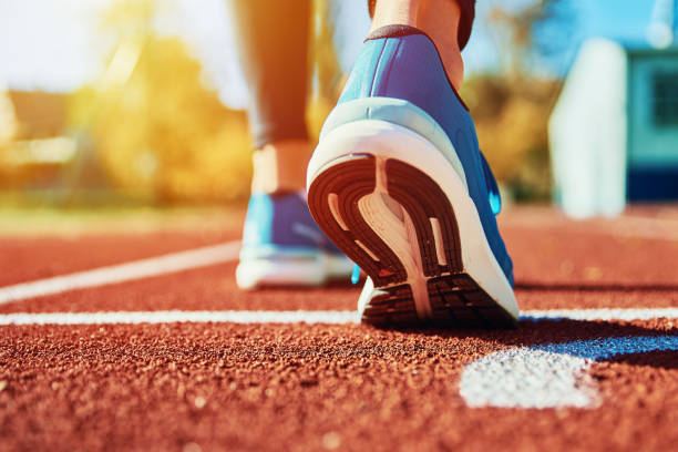 istock Blue sport sjoes at stadium track 1352053545