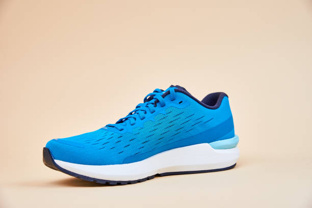 istock Blue running sneaker on beige background, close up 1352053560