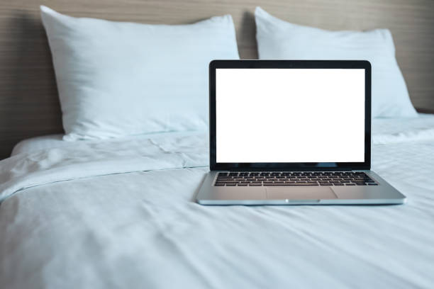 istock Mock up Blank screen laptop on the bed for advertising and text. 1352053596