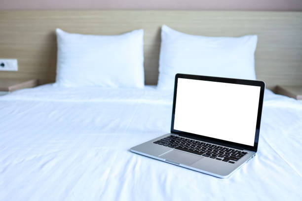 istock Mock up Blank screen laptop on the bed for advertising and text. 1352053600