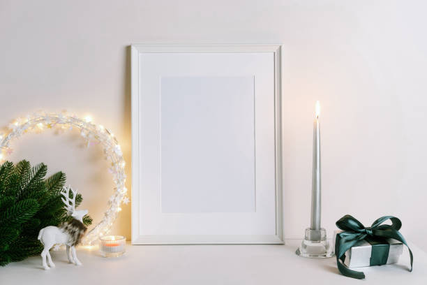 istock Mock up frame with Christmas decorations. Christmas composition with fir tree branch, deer, candle and silver stars on white background. 1352055332