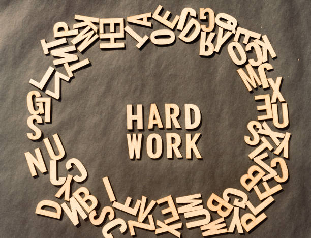 istock Work Hard Word In Wooden Cube Alphabet Letters Top View On A rustic paper Background. 1352055353