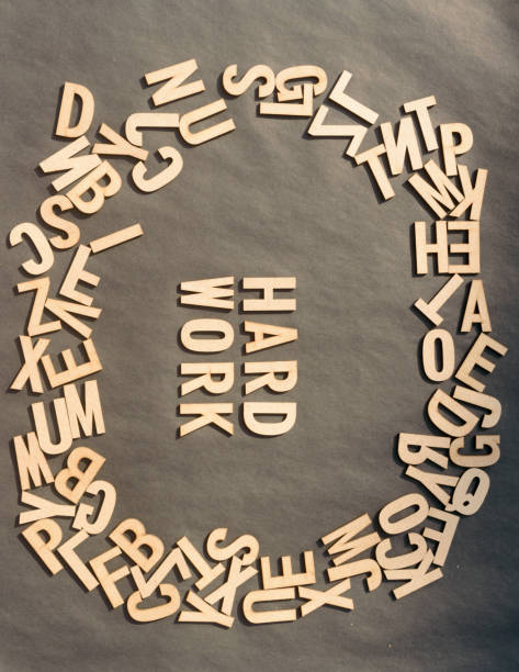 istock Work Hard Word In Wooden Cube Alphabet Letters Top View On A rustic paper Background. 1352055356