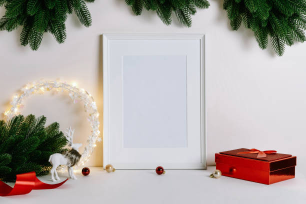 istock Mock up frame with Christmas decorations. Christmas composition with fir tree branch, deer, candle and silver stars on white background. 1352055384