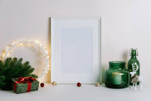 istock Mock up frame with Christmas decorations. Christmas composition with fir tree branch, deer, candle and silver stars on white background. 1352055428