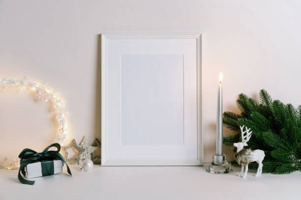 istock Mock up frame with Christmas decorations. Christmas composition with fir tree branch, deer, candle and silver stars on white background. 1352055512