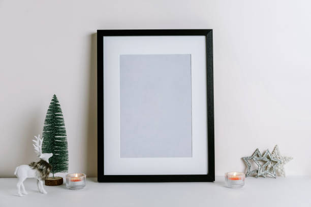 istock Mock up frame with Christmas decorations. Christmas composition with fir tree branch, deer, candle and silver stars on white background. 1352055578
