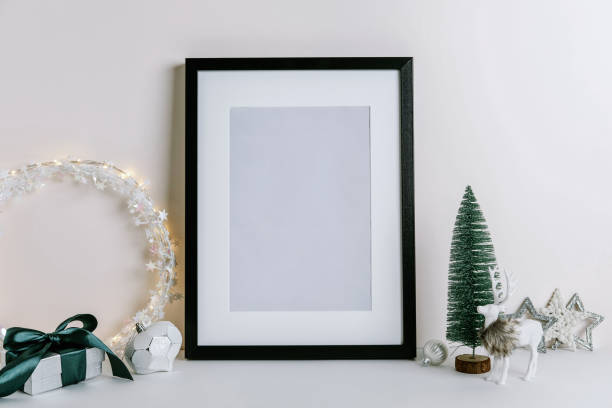 istock Mock up frame with Christmas decorations. Christmas composition with fir tree branch, deer, candle and silver stars on white background. 1352055702
