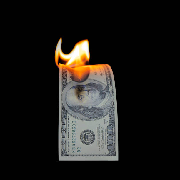 istock US Dollar bill burning in fire flame isolated on black 1352055962