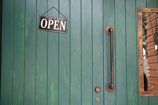 Welcome open sign on shop door .vintage tone stye. Come in we're open