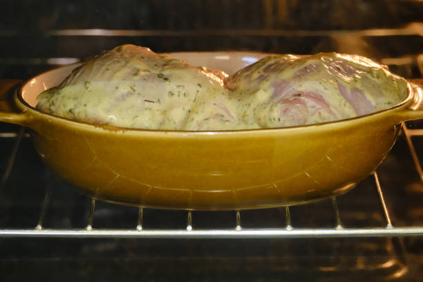 Raw chicken leg thigh in an oven bowl, cooking process