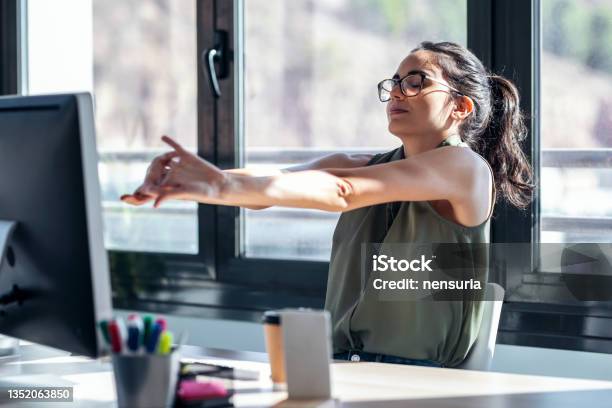 Tired Businesswoman Stretching Body For Relaxing While Working With Computer In The Office Stock Photo - Download Image Now