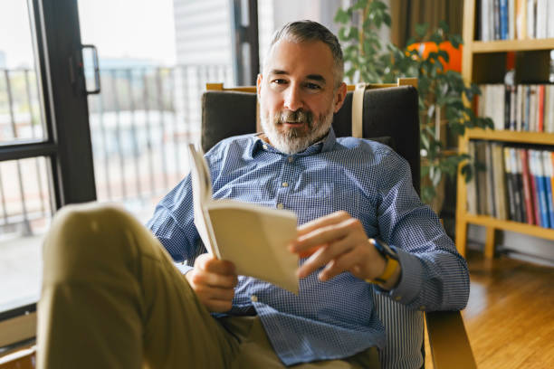 istock mature Man Reading a Book seat look like relax 1352064131