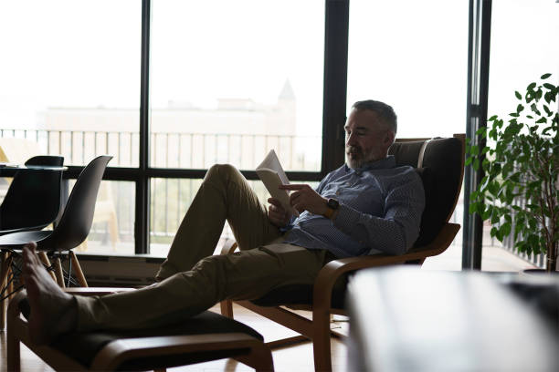 istock mature Man Reading a Book seat look like relax 1352064153