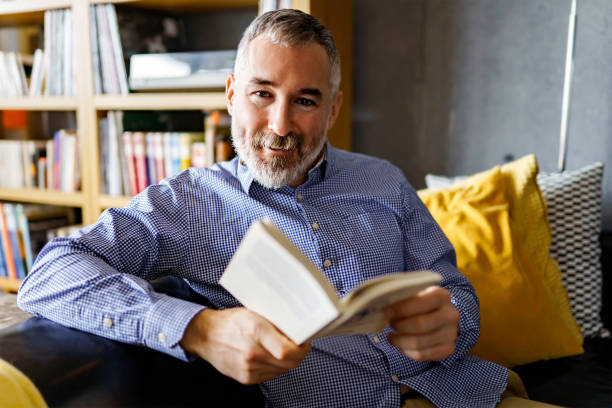 istock mature Man Reading a Book seat look like relax 1352064165