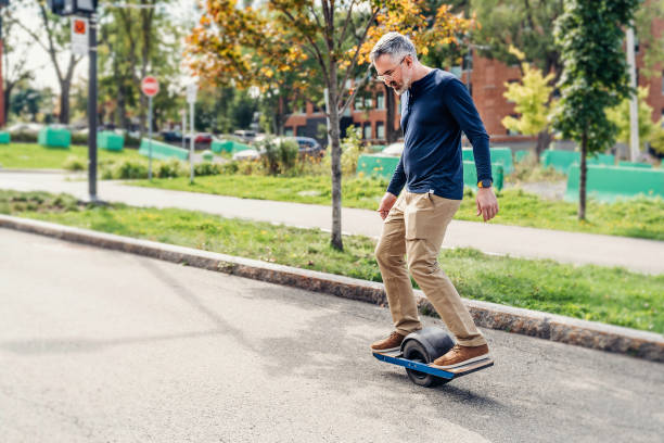 通りに乗って電気トランスポーターを持つ男 - caster board ストックフォトと画像