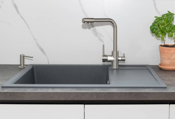 istock Gray kitchen sink with steel tap, potted basil plant 1352065430