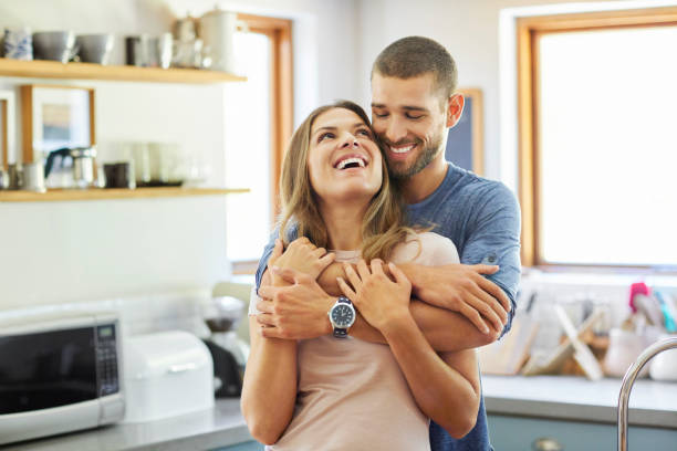 istock Happy romantic couple embracing in kitchen at home 1352065821