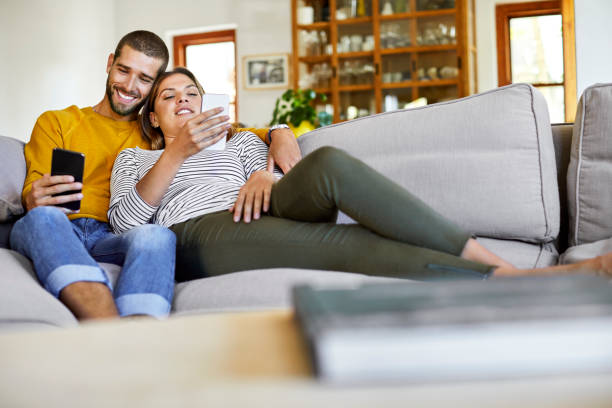 istock Couple using smart phones on sofa at home 1352065851
