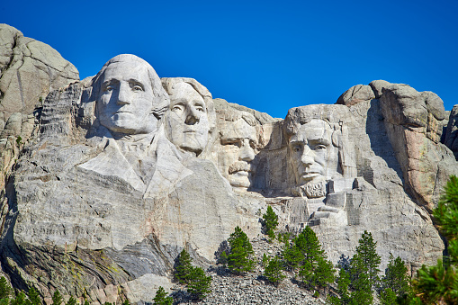 The Mount Rushmore National Memorial is a sculpture carved into the granite face of Mount Rushmore near Keystone, South Dakota, in the United States. Mount Rushmore features 60-foot sculptures of the heads of former United States presidents (in order from left to right) George Washington, Thomas Jefferson, Theodore Roosevelt and Abraham Lincoln.