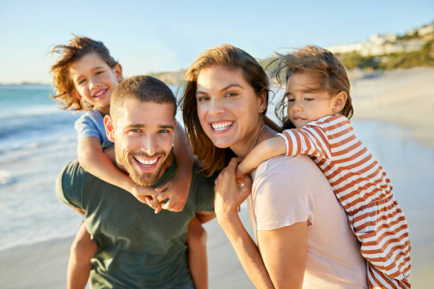 istock Cheerful parents with children at beach 1352067765