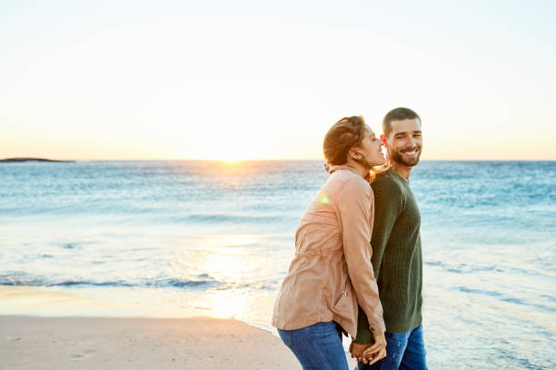 istock Romantic couple at beach during sunset 1352067925