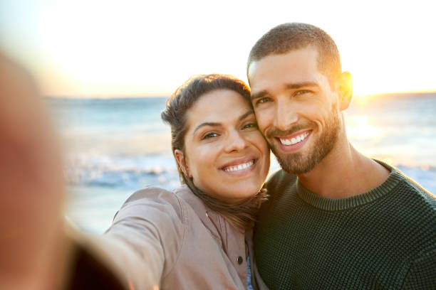 istock Smiling couple taking selfie at beach 1352067926