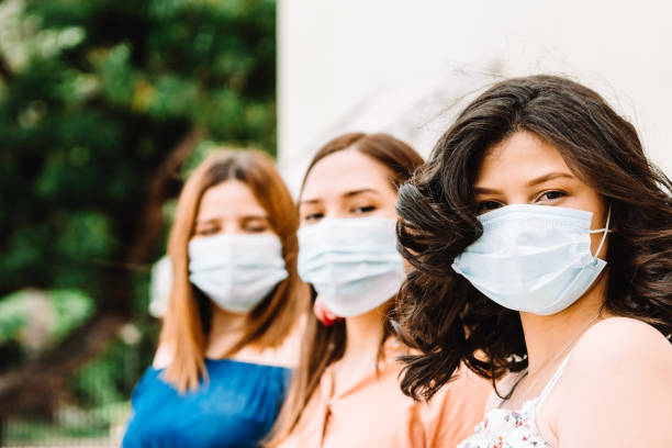 istock latinx friends using face mask, corona virus concept. 1352069872