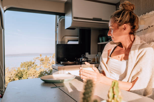 istock Woman drinks coffee in her van, ocean view 1352071135