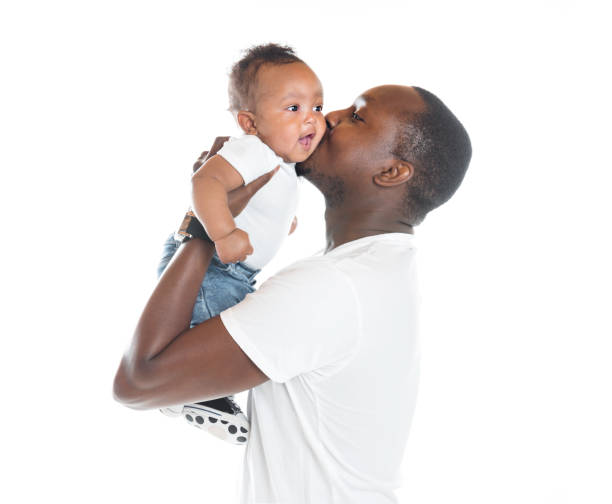 portrait of beautiful african man holding on hands her little son on white background stock photo