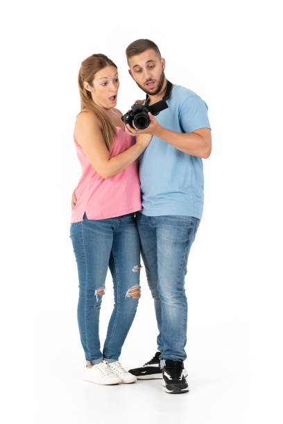 istock Surprised young couple looking at photos on their camera 1352072396
